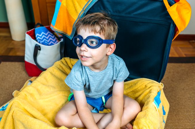 Funny boy smiling sitting inside a suitcase