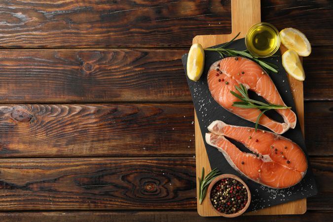 Composition with salmon meat and spices on wooden background, top view