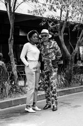 Woman and man pose for a photo on the street in fashionable clothing