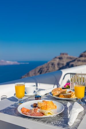 Toast, orange juice, meats and cheese breakfast outside with view of Aegean Sea