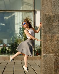 Female in dancing leap near marble column