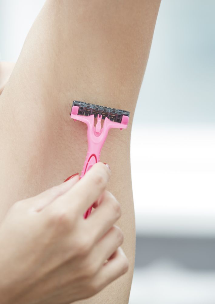 Woman shaving armpit