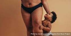 Close up of woman’s postpartum body and child holding on to her leg 0vYjBb