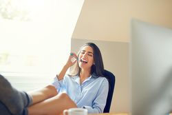 Female smiling using toothbrush in bright room