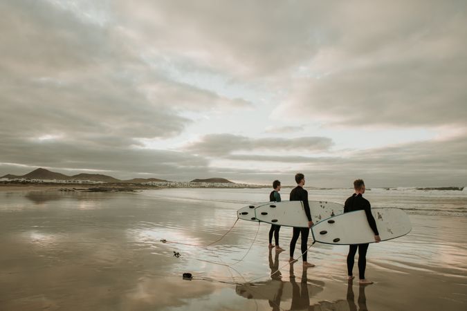 People with surfboard walking near sea