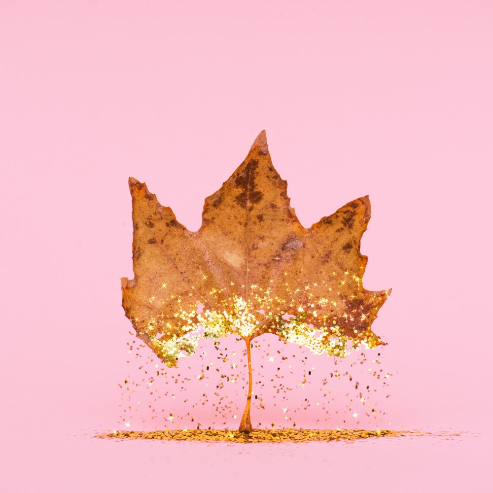 Autumn dry leaf with golden glitter