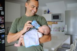 A man holding a baby in a kitchen