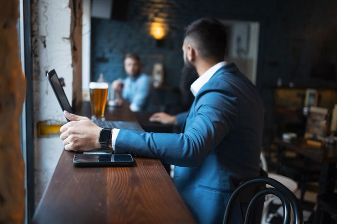 Two men talking across a quiet bar at lunch time