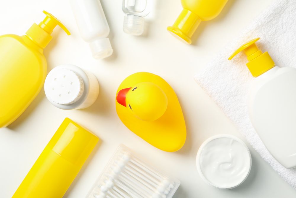 Baby hygiene accessories on light background, top view
