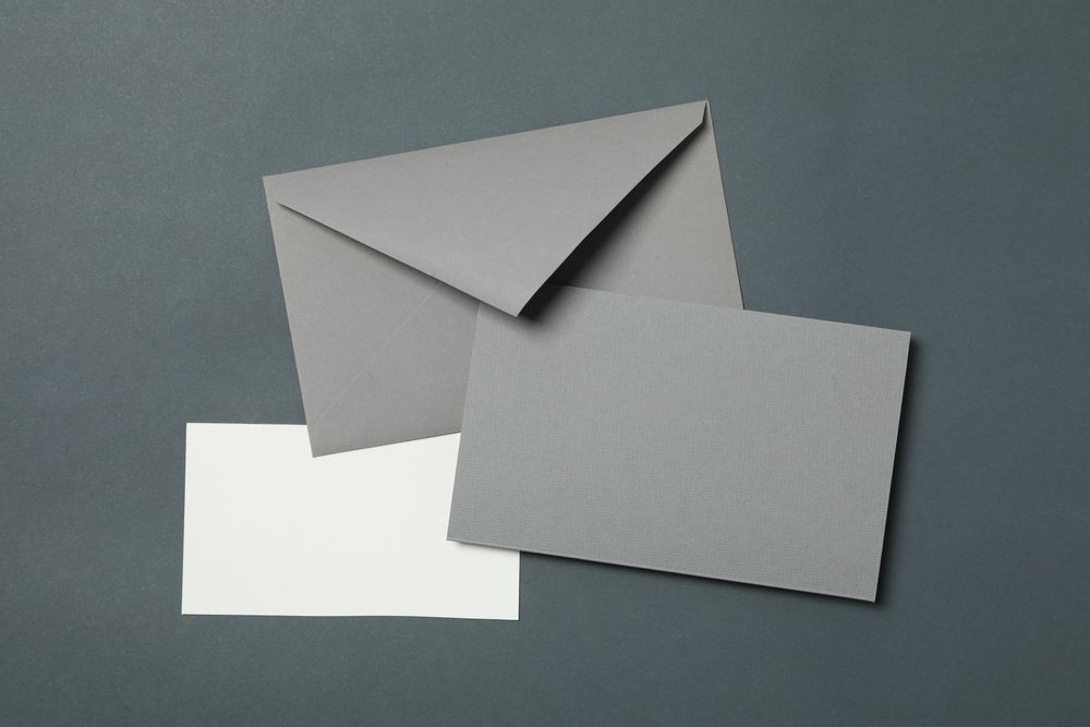 Blank envelope and cards on light dark background, space for text