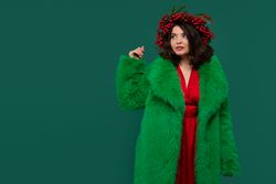 Woman in green faux fur coat and red dress