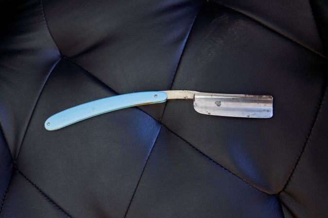 Dangerous sharp razor on leather sofa