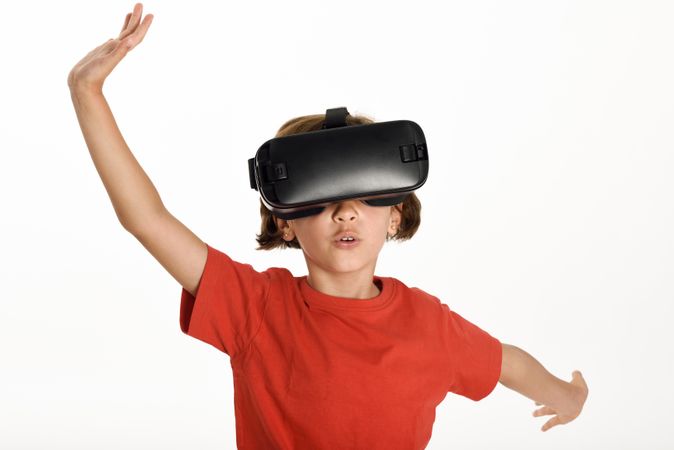 Little girl looking in VR glasses and gesturing with his hands