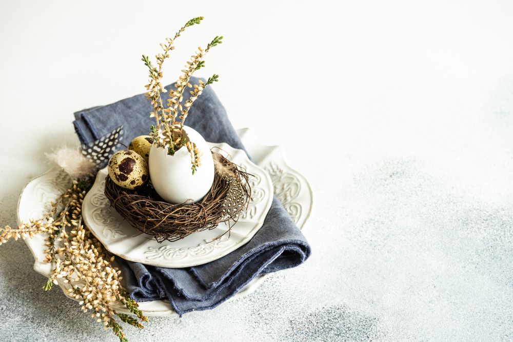 Easter spring card concept with speckled eggs in decorative nest on plate with space for text