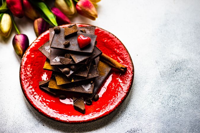 Plate of chocolate with heart next to tulips