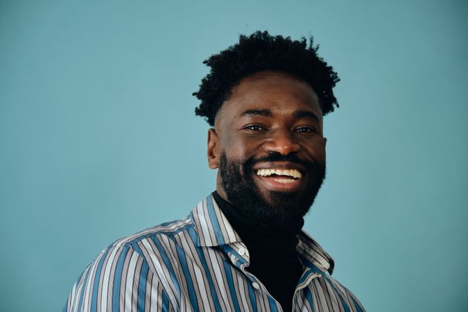 Portrait of a smiling Black man in blue studio shoot