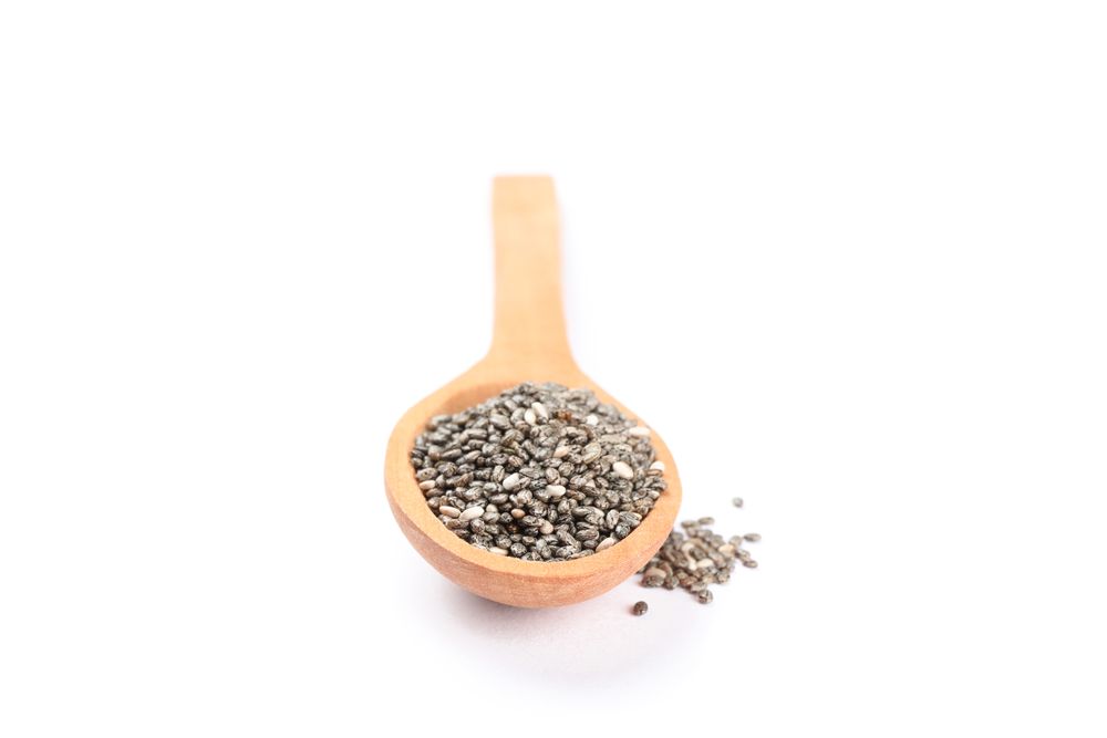 Chia seeds and wooden spoon isolated on plain background