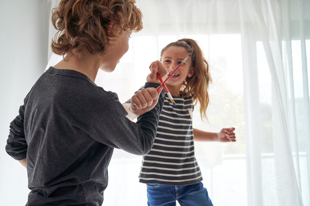 Boy and girl playing with paintbrushes