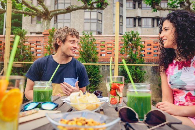 Snacks and drinks enjoyed by man and woman outside