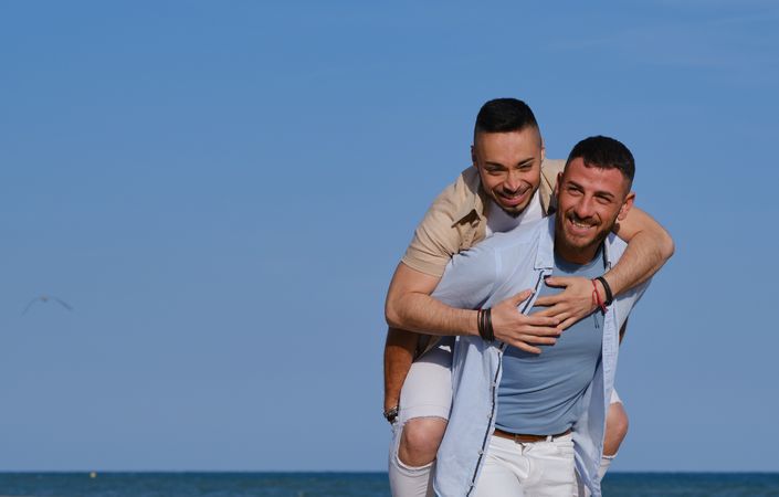 Happy gay couple playing piggyback