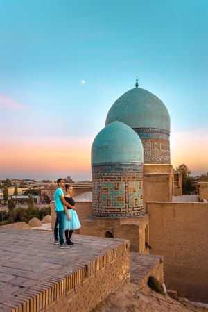 Couple embracing each other near Islamic building