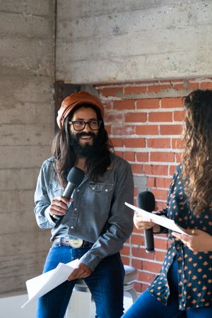 Man smiling at woman while public speaking