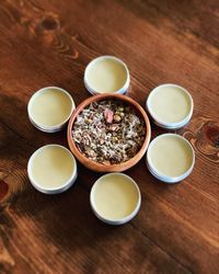 Bowl of herbs surrounded by cannabis salves