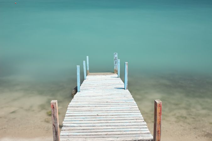 Wooden broken old pier in calm water