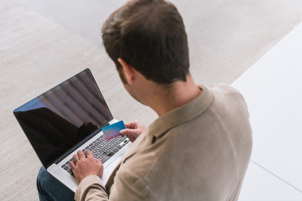 Crop businessman shopping online on street