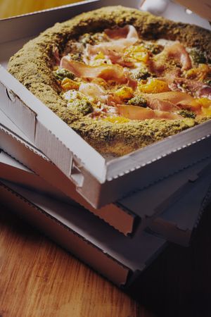 Margherita pizza with basil and tomato served with cold beer on checkered tablecloth