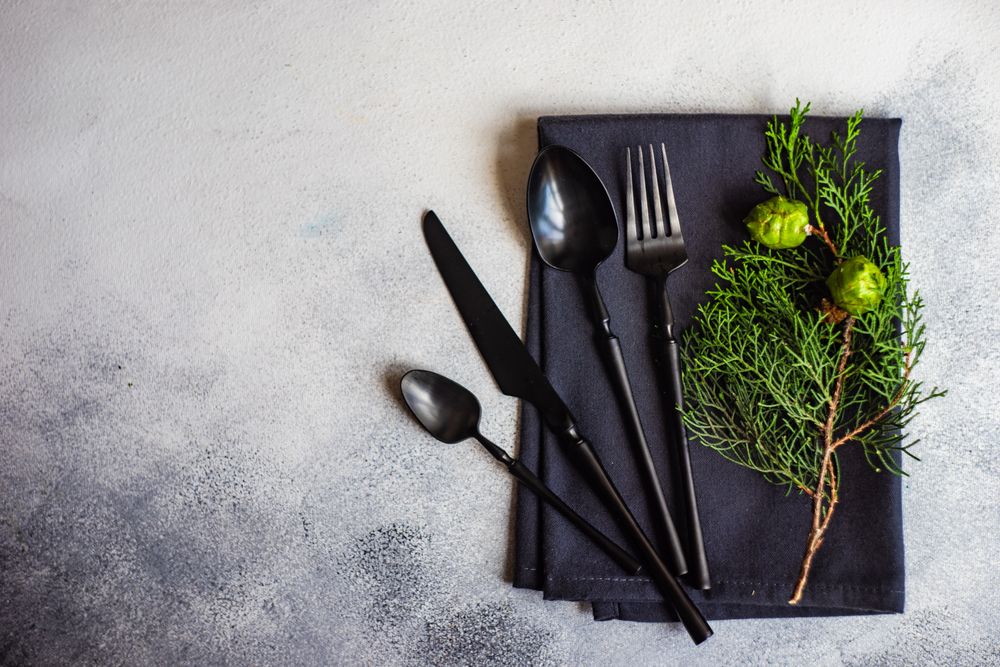 Dark cutlery and napkin with tree shapes sprig for Christmas themed dinner