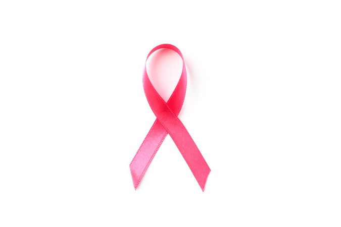 Pink awareness ribbon isolated on blank background, top view