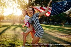 Two girls with USA flag enjoying outdoors 4mnqdb