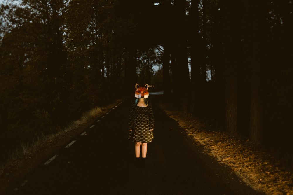 Woman in red fox mask on road