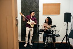 Man playing guitar and woman playing drums