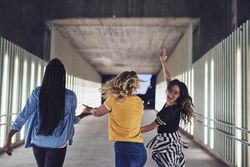 Best friends facing away and walking through structure