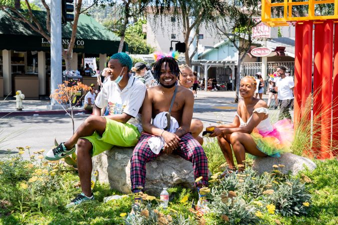 Los Angeles, CA, USA — June 14th, 2020: four people sitting in median at protest smiling at camera