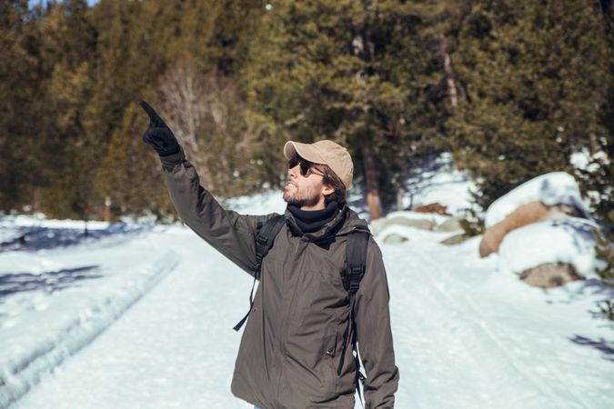 Man between winter forest in sunny day