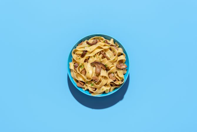 Mushroom pasta dish, above view on a blue background