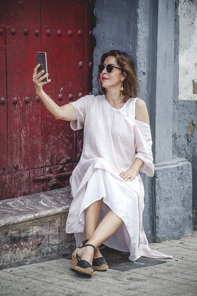 Relaxed female taking selfie with phone on street