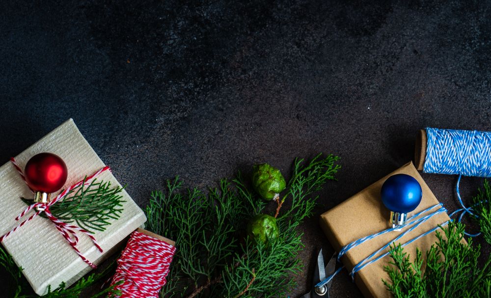 Top view of wrapped Christmas presents with fir and string