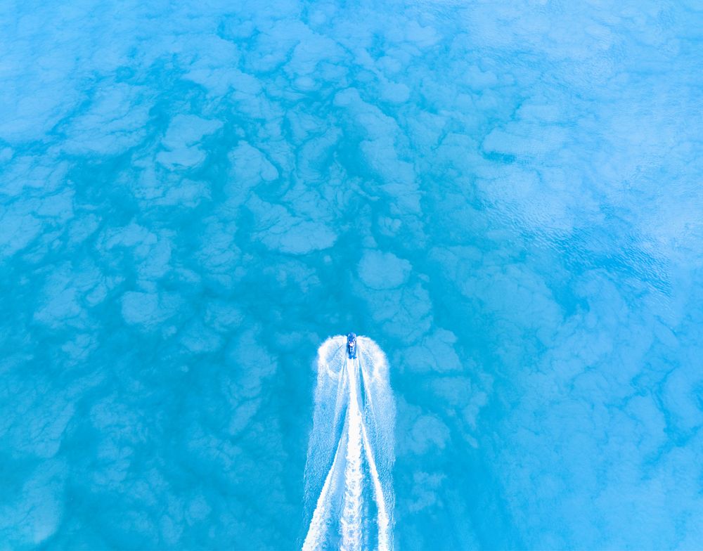 Aerial view of a jet ski racing across the water.