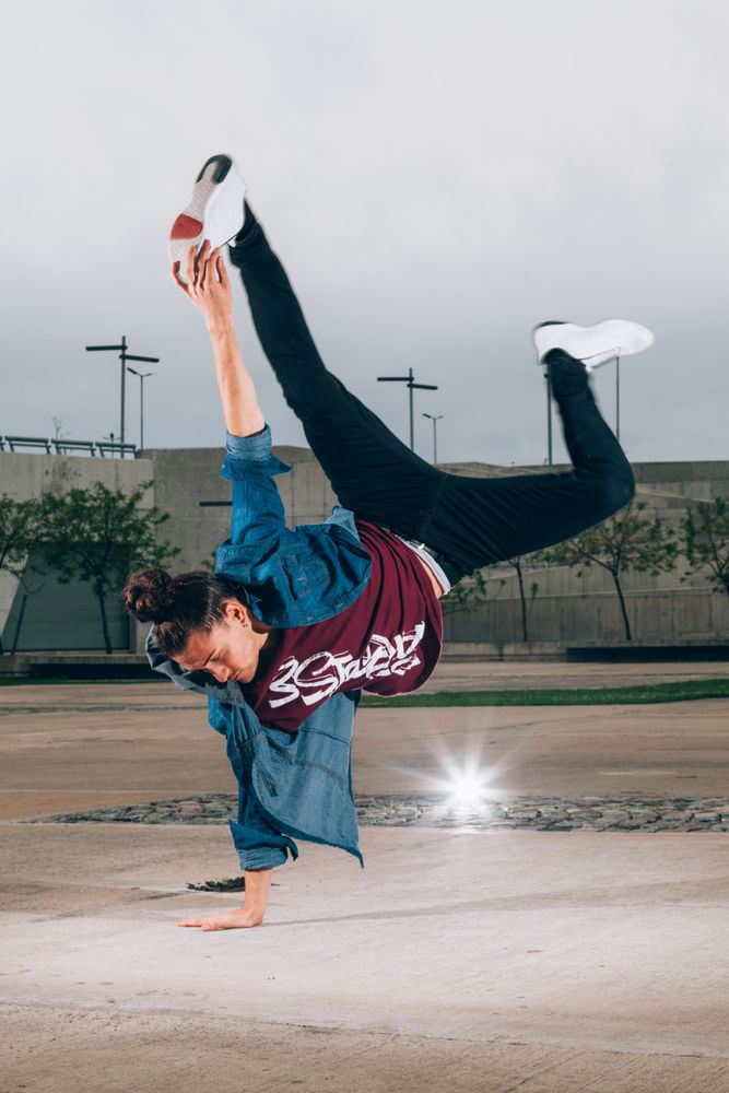 Skillful break dancer performing handstand while moving