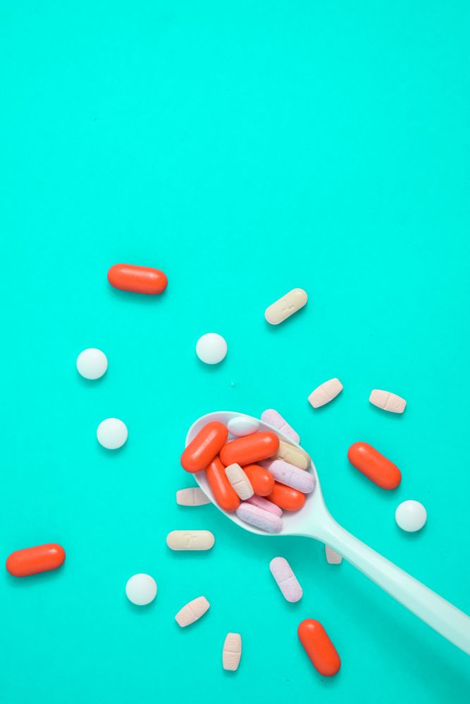 Plastic spoon with various colorful pills 