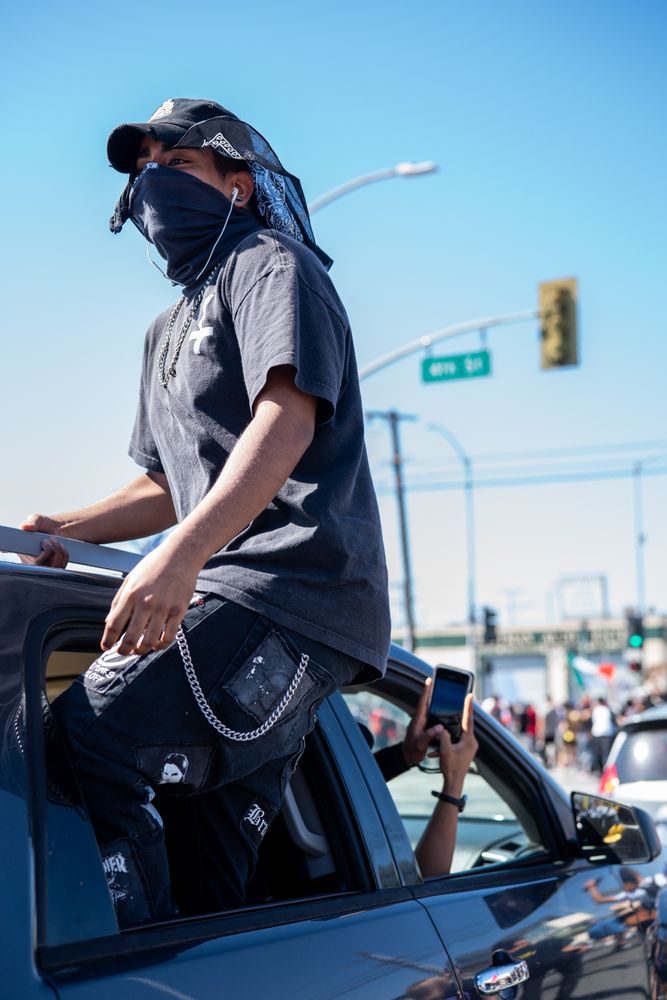 Los Angeles, CA, USA — June 7th, 2020: man standing out of passenger window of car at protest