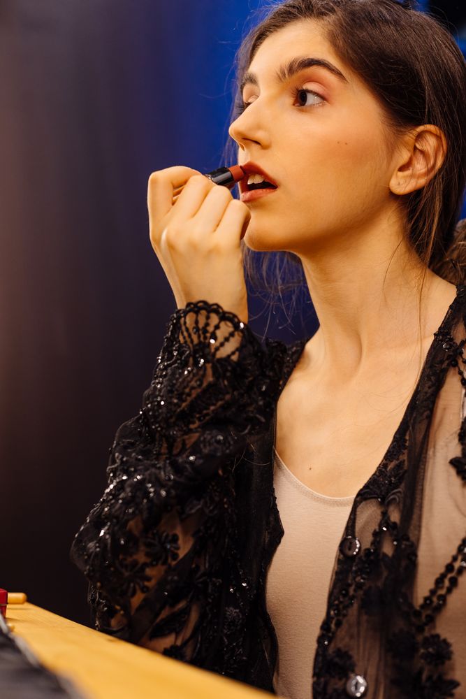 Glamorous female applying lipstick