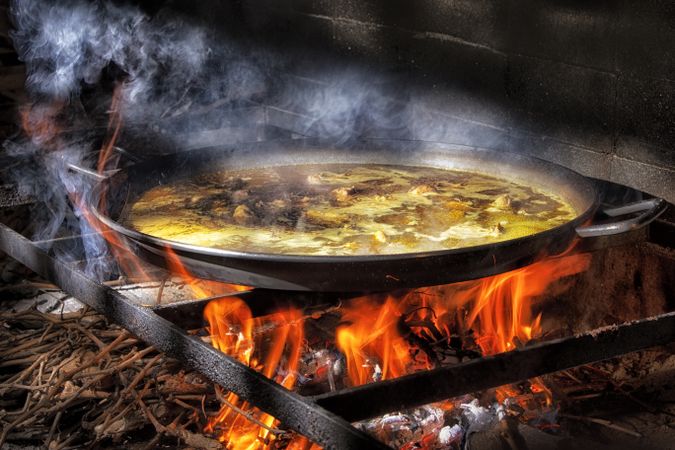 Process of cooking paella on fire