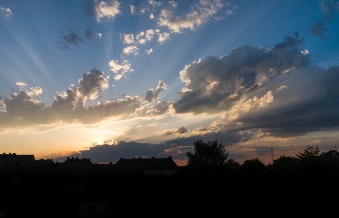 Sun behind clouds over rooftops in France