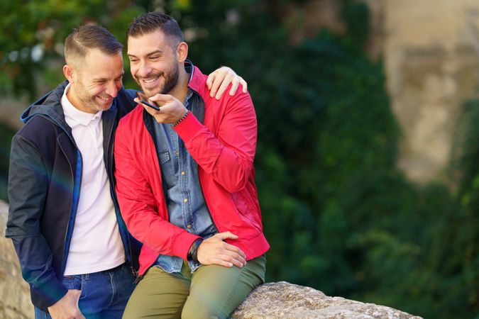 Laughing male couple speaking on phone