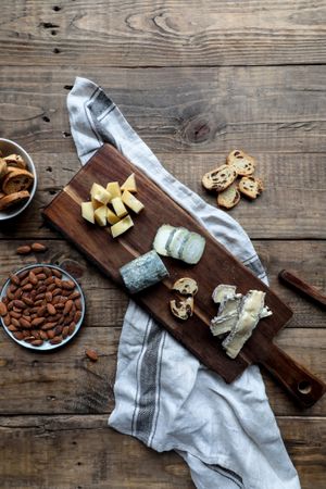 Croutons and nuts near board with cheese